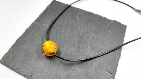 Gintaro pakabukas ant odinės virvelės